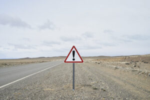 attention road sign next to gravel road