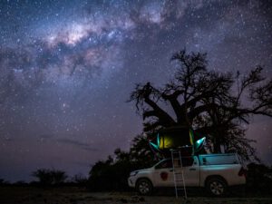 4x4 pickup truck with rooftop tent under milky way at night