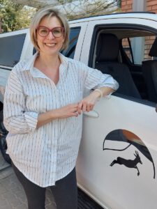 Co-Owner and Manager of Kalahari Car Hire Anika Friedrich standing next to a doublecab