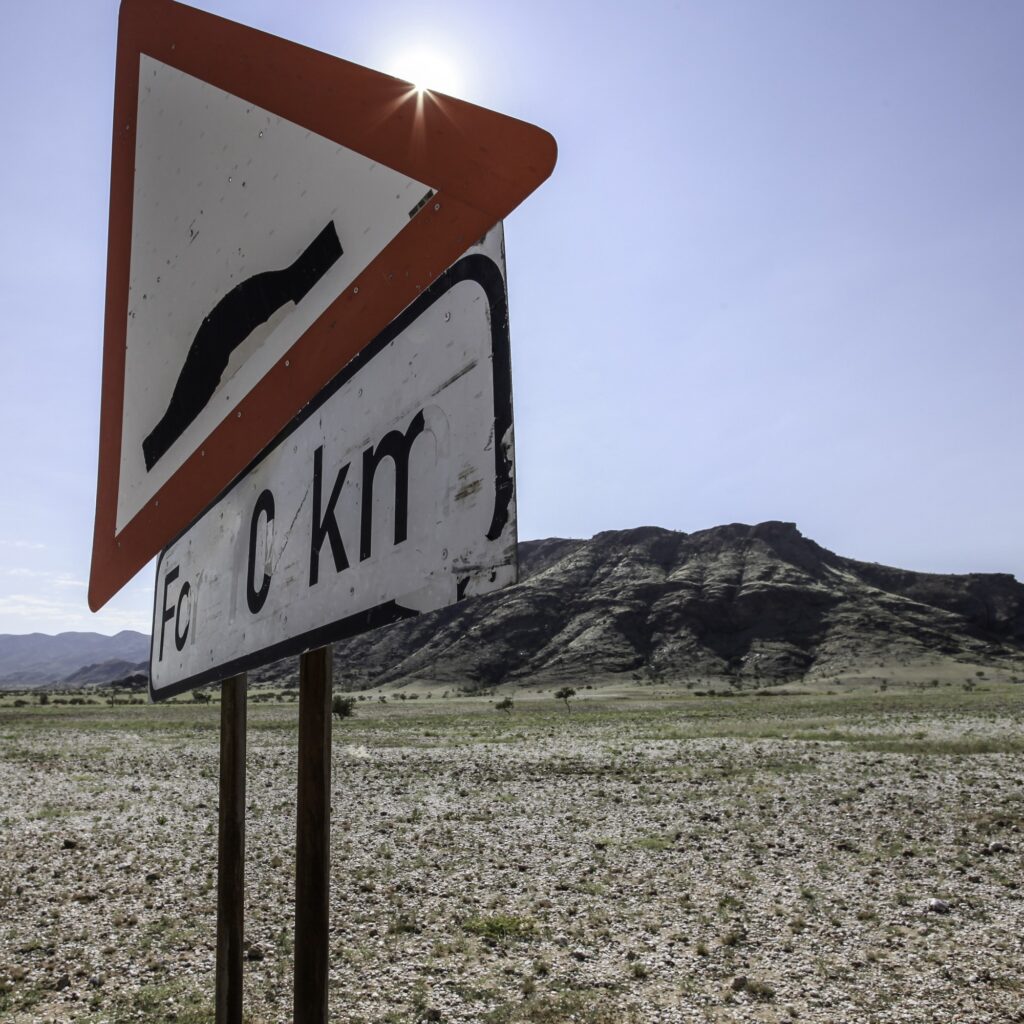 Road sign on gravel road warning of bumpy road ahead